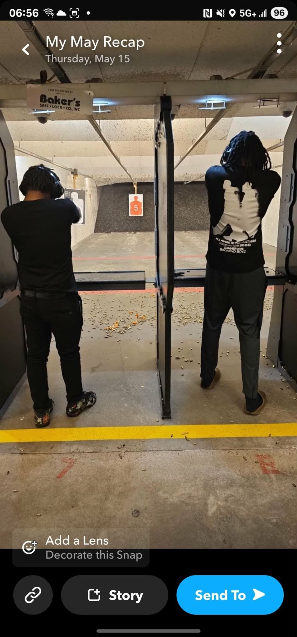 Two people at an indoor shooting range, each at separate stalls aiming firearms at targets downrange